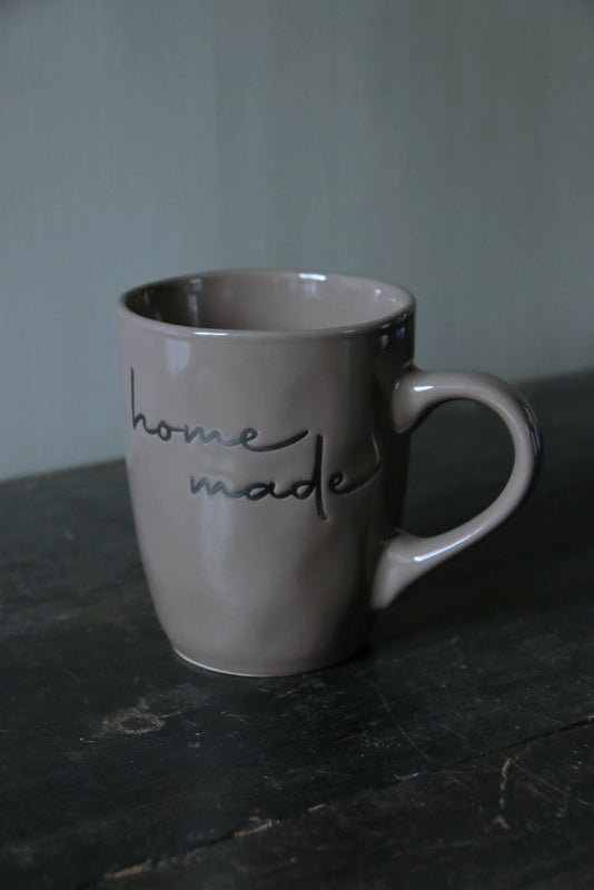 Bruin/taupe mok met de tekst: HOME MADE