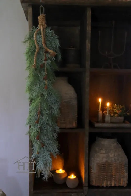 Künstliche Zedernzweiggirlande in realistischer Haptik, 130 cm lang, mit rostigen Metallglöckchen an einem Seil