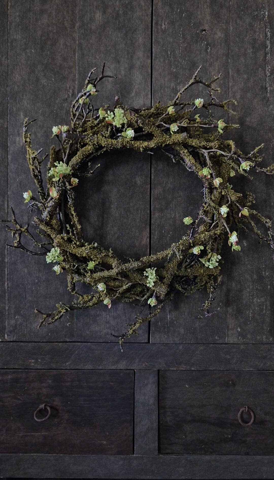 Künstlicher Mooskranz mit weißen Blütenzweigen