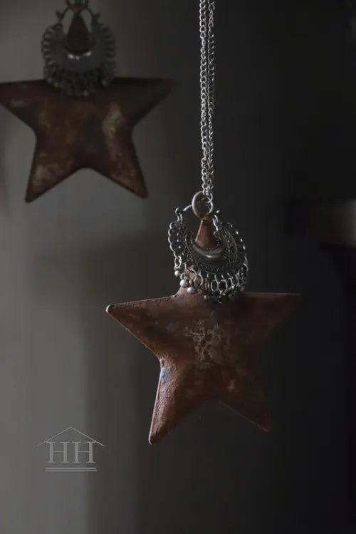 Roestige metalen ster met sieraad