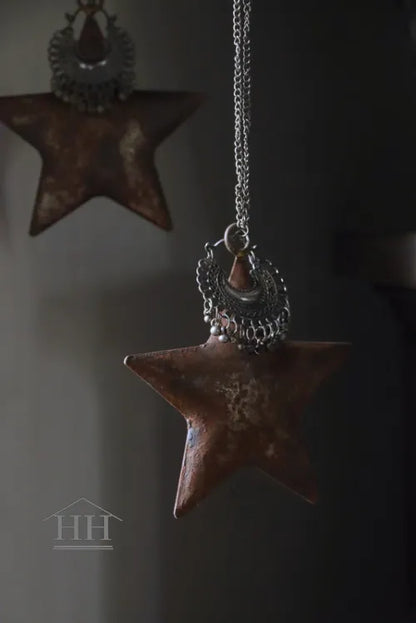 Roestige metalen ster met sieraad