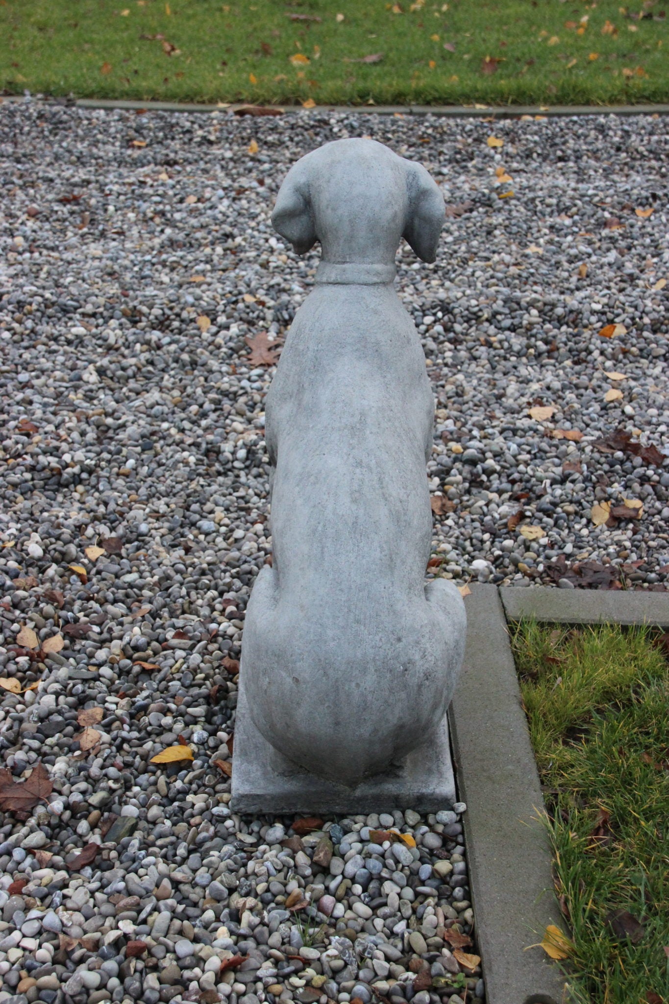 Gartenstatue eines sitzenden Hundes