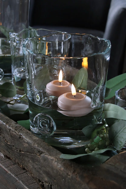 Elektrische drijfkaars roze in een glazen vaas gevuld met water